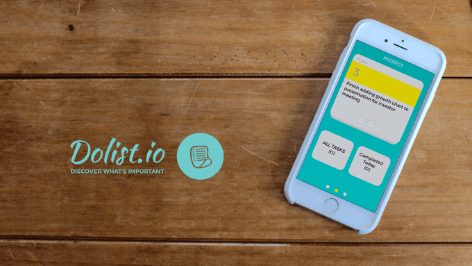 Phone on wood table with dolist logo and tag line, dolist.io discover what's important