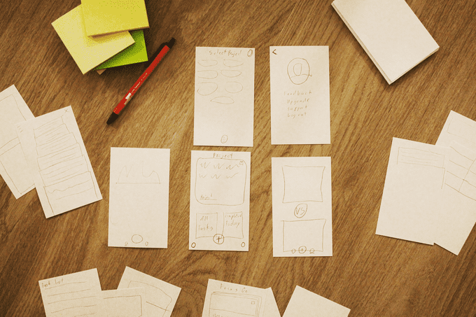 note cards spread out on a wood table with ben and sketches